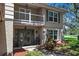 The front entrance to this charming home has a balcony, shade trees, and lovely landscaping at 1310 Rustlewood Dr, Brandon, FL 33510