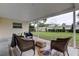 Covered patio with outdoor seating, overlooking the green backyard space at 13344 88Th Ave, Seminole, FL 33776