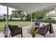 Covered patio with wicker furniture, overlooking a spacious backyard at 13344 88Th Ave, Seminole, FL 33776