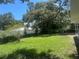 Spacious backyard with mature trees, lush green lawn, and a white vinyl fence for added privacy at 13344 88Th Ave, Seminole, FL 33776