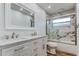 Bathroom featuring a double vanity, marble-style tile, and shower at 13344 88Th Ave, Seminole, FL 33776