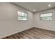 A bright bedroom featuring two windows and wood-look floors at 13344 88Th Ave, Seminole, FL 33776