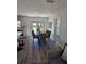 Dining room with seating for six, adjacent to kitchen with gray chairs and outdoor view through french doors at 13344 88Th Ave, Seminole, FL 33776