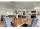 Bright dining room featuring an oak table and grey chairs, connecting seamlessly to a modern, well-lit kitchen at 13344 88Th Ave, Seminole, FL 33776