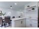 Kitchen and Dining Area featuring a breakfast bar, open shelving, and lots of bright, natural light at 13344 88Th Ave, Seminole, FL 33776