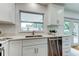 Bright, modern kitchen features stainless steel appliances, quartz countertops, and view to outside at 13344 88Th Ave, Seminole, FL 33776