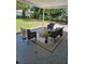Back patio has a seating area with cushioned wicker furniture, an area rug, and a view of the spacious backyard at 13344 88Th Ave, Seminole, FL 33776