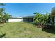 Expansive backyard featuring a lawn, privacy fence, and tropical landscaping at 14060 102Nd Ave, Largo, FL 33774