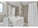 Stylish bathroom features a shower with curtain, neutral tile, and a single sink vanity with chrome fixtures at 14060 102Nd Ave, Largo, FL 33774