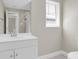 The bright bathroom features a modern single sink vanity and a shower with curtain, well lit by a large window at 14060 102Nd Ave, Largo, FL 33774