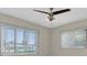 This light bedroom features a modern ceiling fan, tile floors, and ample natural light from large windows at 14060 102Nd Ave, Largo, FL 33774