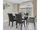 Modern dining room features a glass table, leather chairs, neutral decor, and a contemporary chandelier at 14060 102Nd Ave, Largo, FL 33774