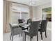 This dining room features a glass table, leather chairs, neutral decor, contemporary chandelier, and natural light at 14060 102Nd Ave, Largo, FL 33774