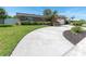 Beautiful home with lush green lawn, mature landscaping, circular driveway, and brick accent wall at 14060 102Nd Ave, Largo, FL 33774