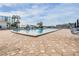 A view of the community pool area with surrounding buildings, blue skies, palm trees and lounge seating at 14060 102Nd Ave, Largo, FL 33774
