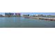 Scenic waterfront view with a long wooden pier/dock, nearby community buildings, and blue skies at 14060 102Nd Ave, Largo, FL 33774