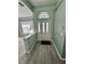 Inviting foyer featuring wood-look flooring, a half-wall partition, and a decorative glass door at 15101 Bald Eagle St, Tampa, FL 33625