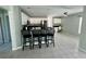 Open kitchen with white cabinets, black countertops, stainless steel appliances, and bar seating at 15101 Bald Eagle St, Tampa, FL 33625