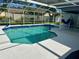 Inviting screened-in pool area with clear blue water, a surrounding patio, and a glimpse of the backyard at 15101 Bald Eagle St, Tampa, FL 33625