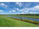 A serene water view from a well-maintained green backyard, perfect for outdoor enjoyment at 16972 Oval Rum Dr, Wimauma, FL 33598