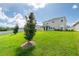 Beautifully landscaped backyard with healthy green grass and a covered porch at 16972 Oval Rum Dr, Wimauma, FL 33598