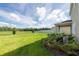 View of the large backyard with green grass and view of the community landscape at 16972 Oval Rum Dr, Wimauma, FL 33598
