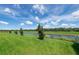 Picturesque backyard overlooking a serene canal, featuring a lush green lawn and mature trees at 16972 Oval Rum Dr, Wimauma, FL 33598