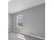 A gray bedroom with carpet and natural light coming through a window at 16972 Oval Rum Dr, Wimauma, FL 33598