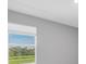 Bright bedroom showcasing a window overlooking a lush green landscape at 16972 Oval Rum Dr, Wimauma, FL 33598