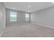 A spacious bedroom with plush carpeting, two windows, and neutral paint for a calming atmosphere at 16972 Oval Rum Dr, Wimauma, FL 33598