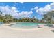 Zero entry resort-style community pool with lounge chairs and beautiful palm trees at 16972 Oval Rum Dr, Wimauma, FL 33598
