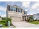 Charming two-story home featuring a large front yard, two car garage and manicured landscaping at 16972 Oval Rum Dr, Wimauma, FL 33598