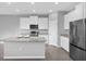 Bright and modern kitchen with stainless steel appliances, white cabinets, and a gray countertop island at 16972 Oval Rum Dr, Wimauma, FL 33598