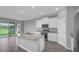 Contemporary kitchen with a large island, stainless steel appliances, and sliding glass doors to the backyard at 16972 Oval Rum Dr, Wimauma, FL 33598