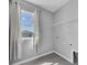 Practical laundry room with tile flooring, storage shelf and window with curtains at 16972 Oval Rum Dr, Wimauma, FL 33598