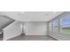 Bright, open-concept living room with staircase and large windows at 16972 Oval Rum Dr, Wimauma, FL 33598