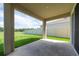 Covered outdoor patio with views of the green lawn, ideal for relaxing and outdoor entertaining at 16972 Oval Rum Dr, Wimauma, FL 33598