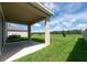Covered outdoor patio with views of the beautiful green lawn and trees in the distance at 16972 Oval Rum Dr, Wimauma, FL 33598