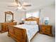 Bright bedroom with a wooden bed frame, coastal-themed decor, and a ceiling fan for added comfort at 1712 Azalea Ct # B, Oldsmar, FL 34677