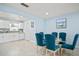 Open floor plan with a dining area featuring a glass table, blue chairs, and a view into the kitchen at 1712 Azalea Ct # B, Oldsmar, FL 34677