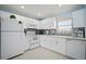Bright kitchen featuring white cabinetry, tile backsplash, and modern appliances, offering a clean and functional space at 1712 Azalea Ct # B, Oldsmar, FL 34677