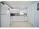 A bright kitchen with white cabinets, modern appliances, tile floors, and light blue walls at 1712 Azalea Ct # B, Oldsmar, FL 34677