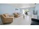 Bright living room features tile floors, comfortable seating, and sliding glass doors to an outdoor patio at 1712 Azalea Ct # B, Oldsmar, FL 34677