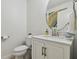 Cozy half-bath features a sleek vanity with a round mirror and marble countertop at 17880 Althea Blue Pl, Lutz, FL 33558