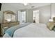 Bedroom with hardwood floors, decorative bed, and dresser with mirror at 17880 Althea Blue Pl, Lutz, FL 33558