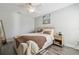 Bright bedroom with a ceiling fan, a comfy bed, and plank flooring at 17880 Althea Blue Pl, Lutz, FL 33558