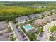 Aerial view showcases community pool and surrounding townhomes with lush landscaping and parking at 17880 Althea Blue Pl, Lutz, FL 33558