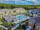 Aerial view featuring a community pool and surrounding townhomes in a well-landscaped neighborhood at 17880 Althea Blue Pl, Lutz, FL 33558