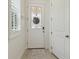 Clean entryway with a white door, light wood floors, and a decorative window at 17880 Althea Blue Pl, Lutz, FL 33558