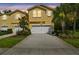 Charming yellow townhome with a two-car garage and well-maintained landscaping at 17880 Althea Blue Pl, Lutz, FL 33558